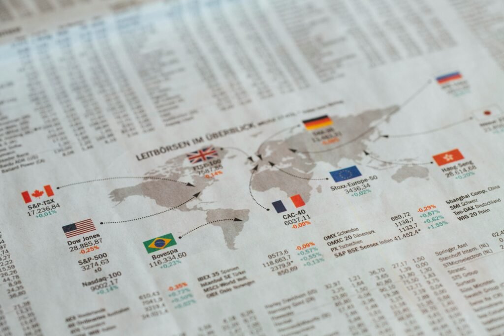Página de jornal financeiro exibindo mapa-múndi com indicadores econômicos de diversos países, incluindo Dow Jones (EUA), Bovespa (Brasil), índices europeus e asiáticos